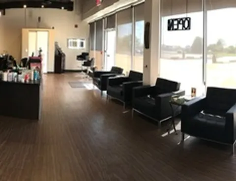 Neo Bella's waiting area with black leather chairs